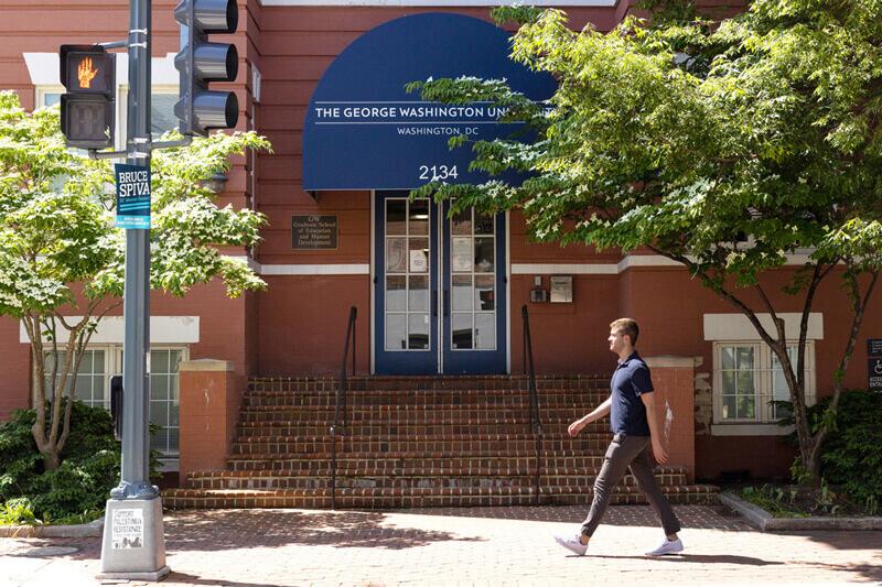 A person walking in front of the Graduate School of Education and Human Development building on GW's Foggy Bottom campus.